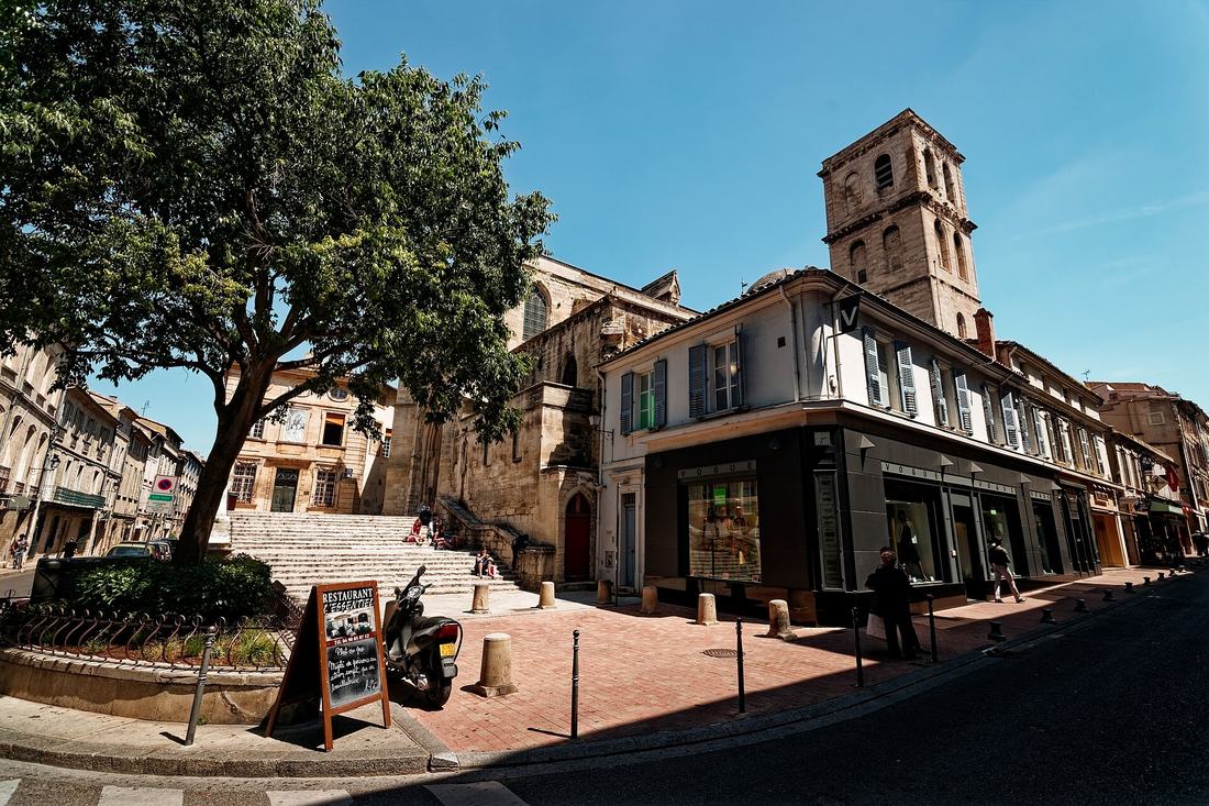 La rue Saint-Agricol à Avignon, ses vitrines et le clocher de la collégiale